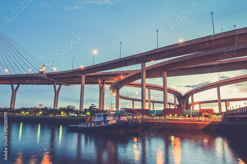 Boat on river with Bhumibol Bridge background in twilight time.