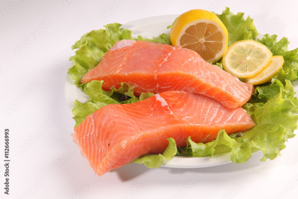 salmon on a plate with salad and lemon