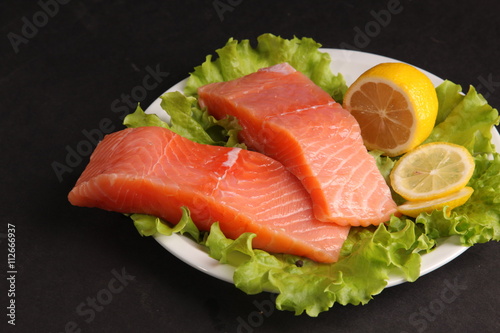 salmon on a plate with salad and lemon