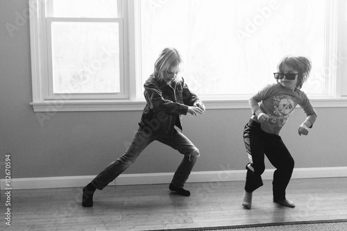 Two young brothers dancing in empty room, black and white
