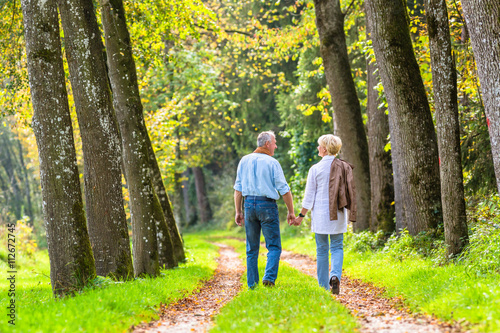 Senior man and woman holding hand walking