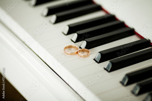 Wallpaper Mural Two beautiful wedding rings on piano keyboard in close-up Torontodigital.ca