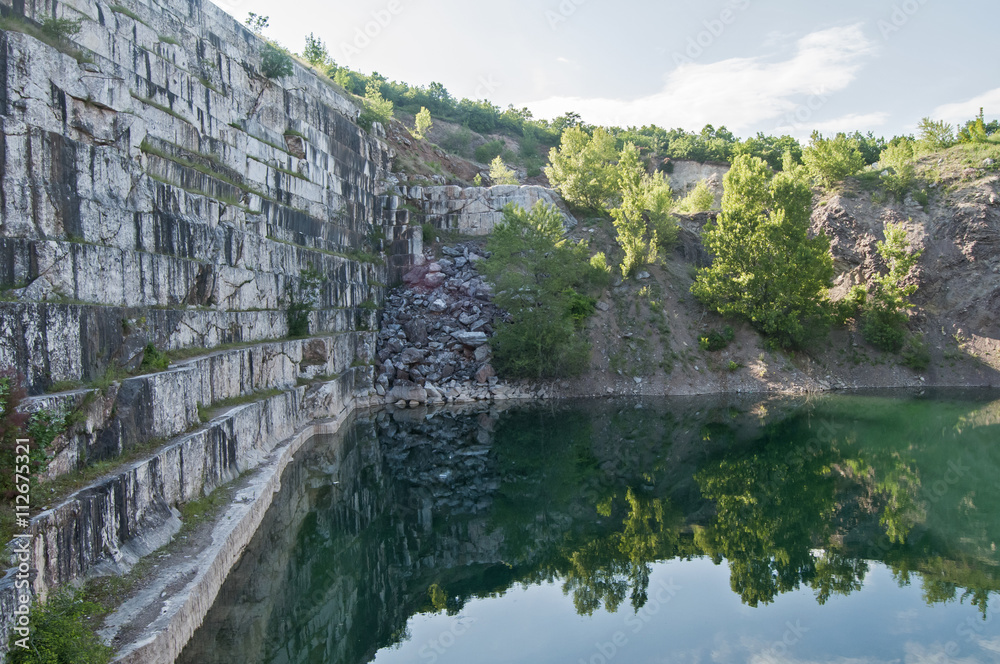 Overlooking the wall of abandoned marble quarry and pond