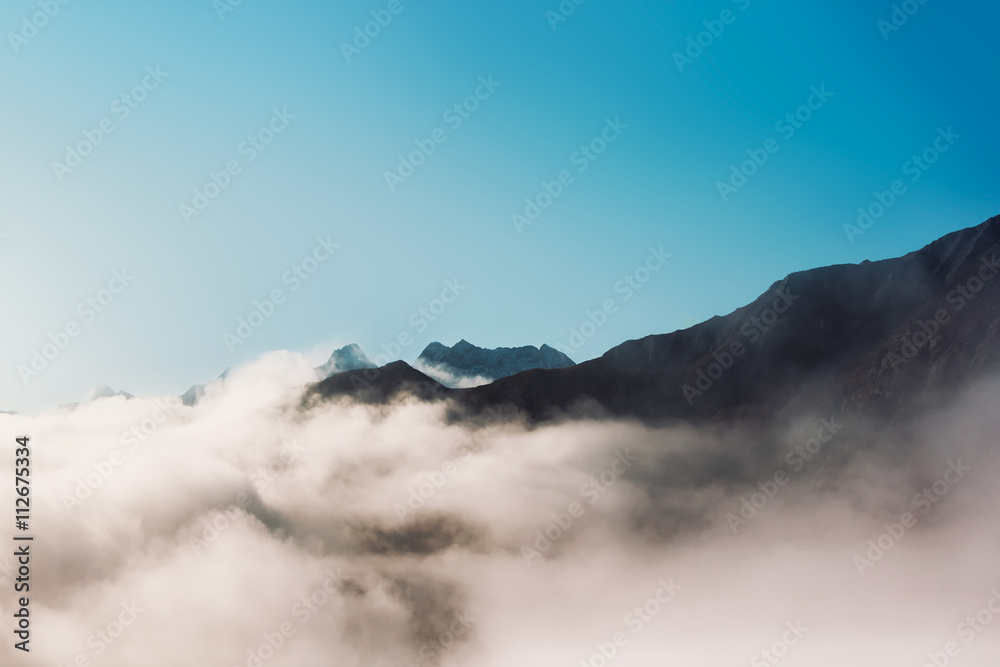 Mountain peak protruding from clouds Mountain peak protruding from clouds