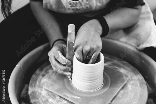 Hands of person forming clay on potters wheel