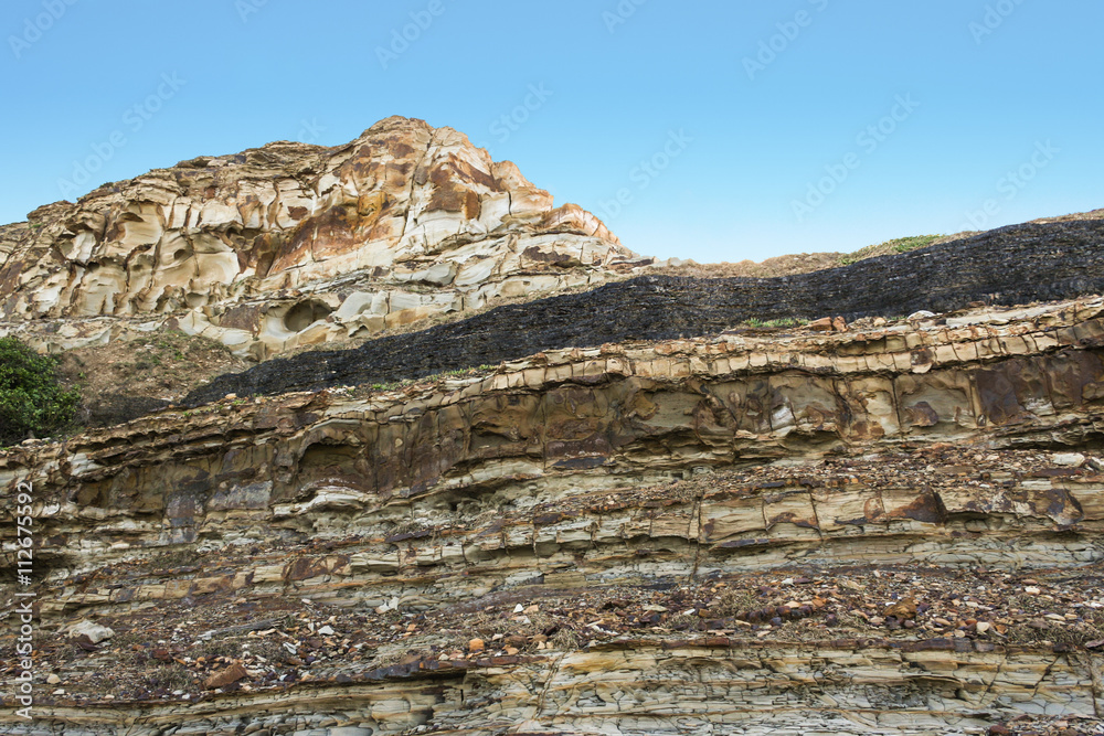 Dark coal seam in sedimentary layers in cliff. Newcastle, New South Wales, Australia. Dark coal seam in sedimentary layers in cliff. Newcastle, New South Wales, Australia.