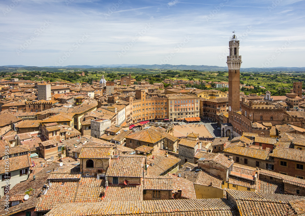 view to roofs and city square with old tower in Tuscany in Italy