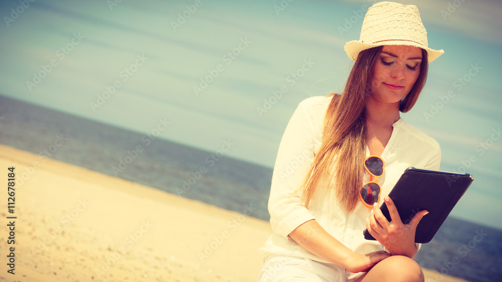 Girl with tablet on seaside.