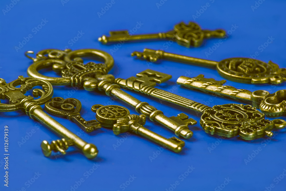 Group of Brass Antique Skeleton Keys on Blue Background