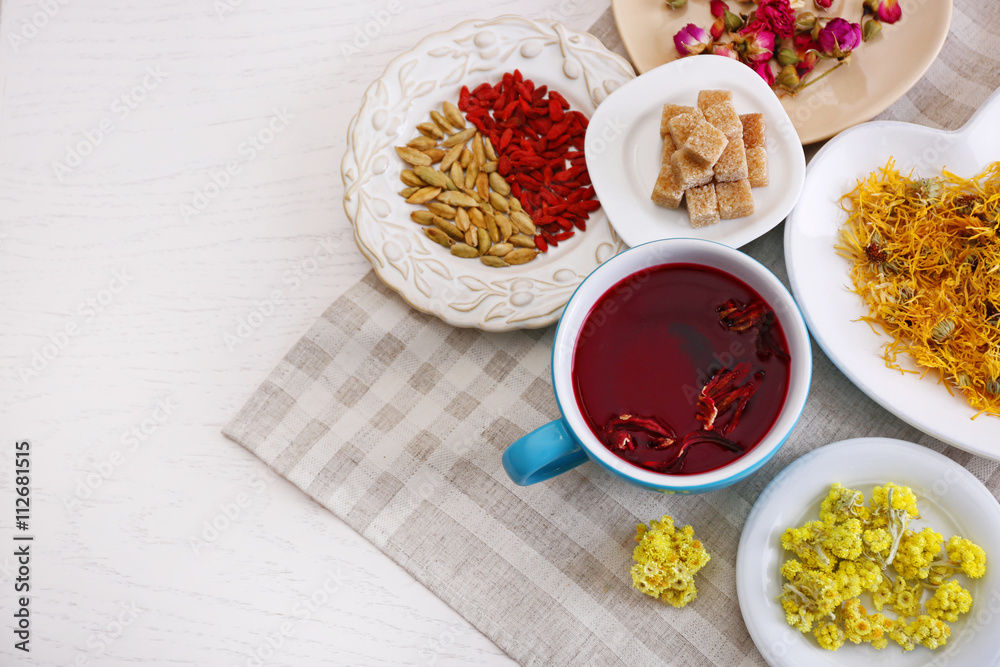 Cup of tea with aromatic dry tea on wooden background