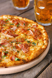 Delicious pizza  and glasses of beer are on wooden table, close up