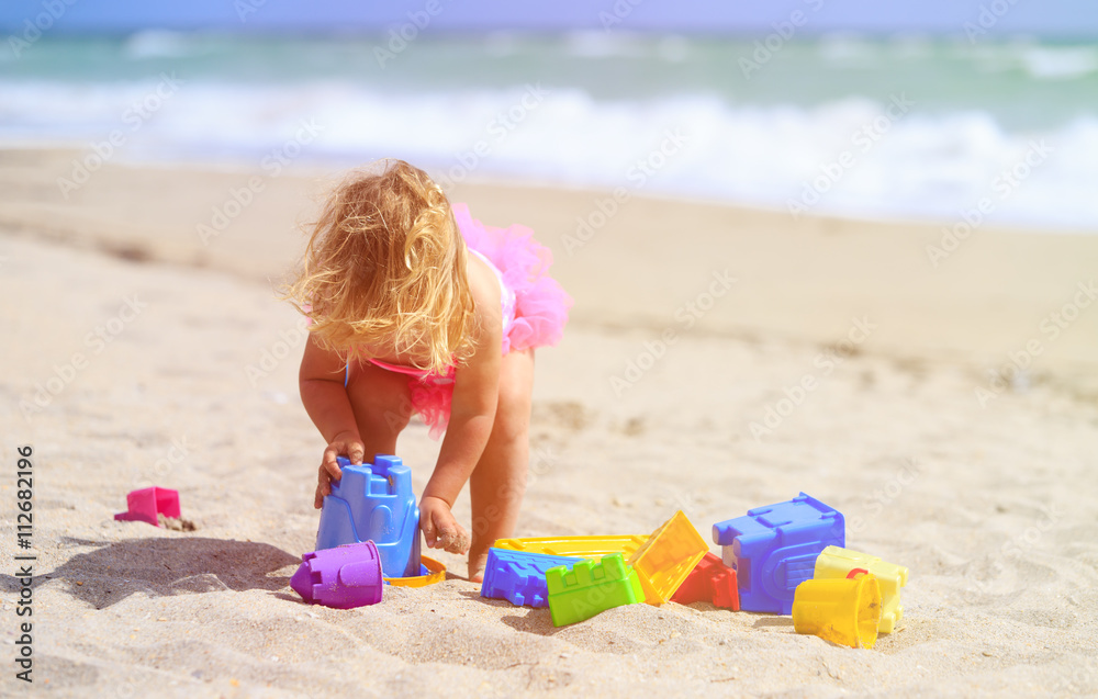 cute little girl play with sand on beach cute little girl play with sand on beach