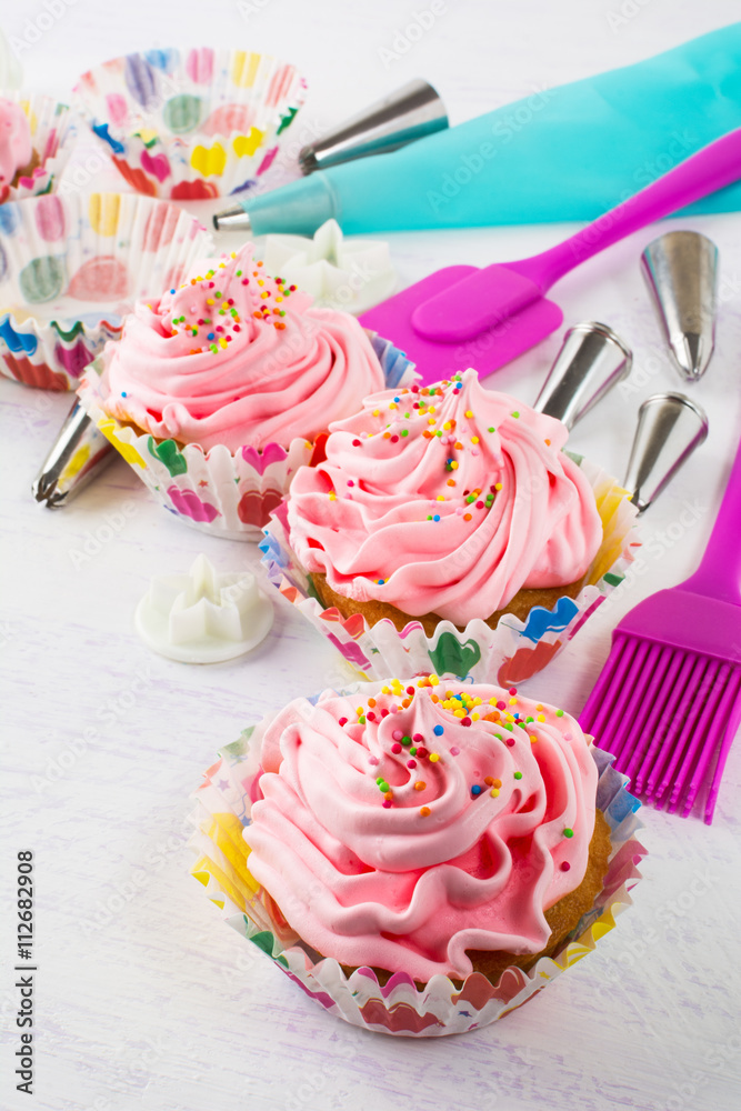 Pink cupcakes  and kitchen utensils, vertical