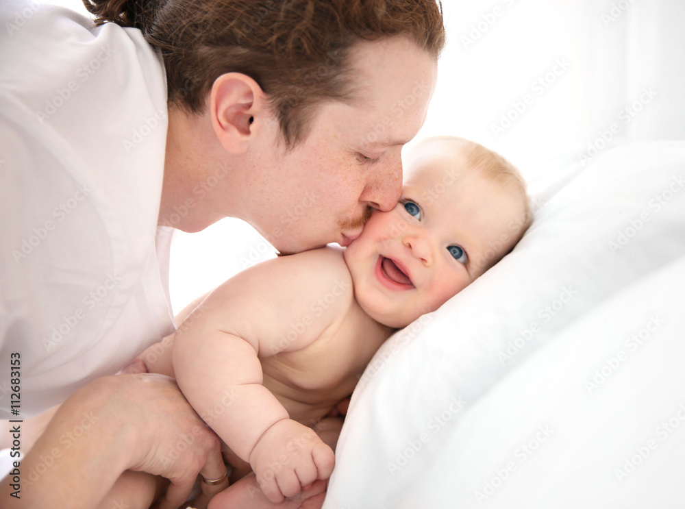 Young father kissing his little baby Young father kissing his little baby