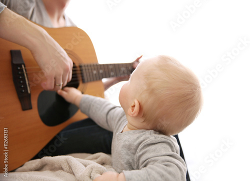 Father playing guitar to hi...