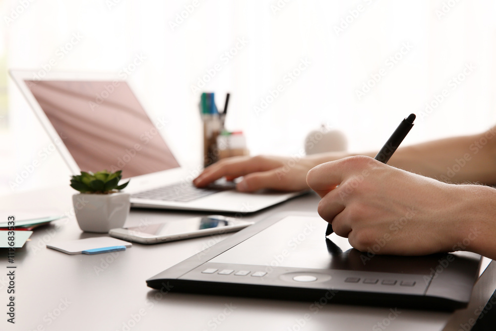 Fototapeta premium Man using graphic tablet at office
