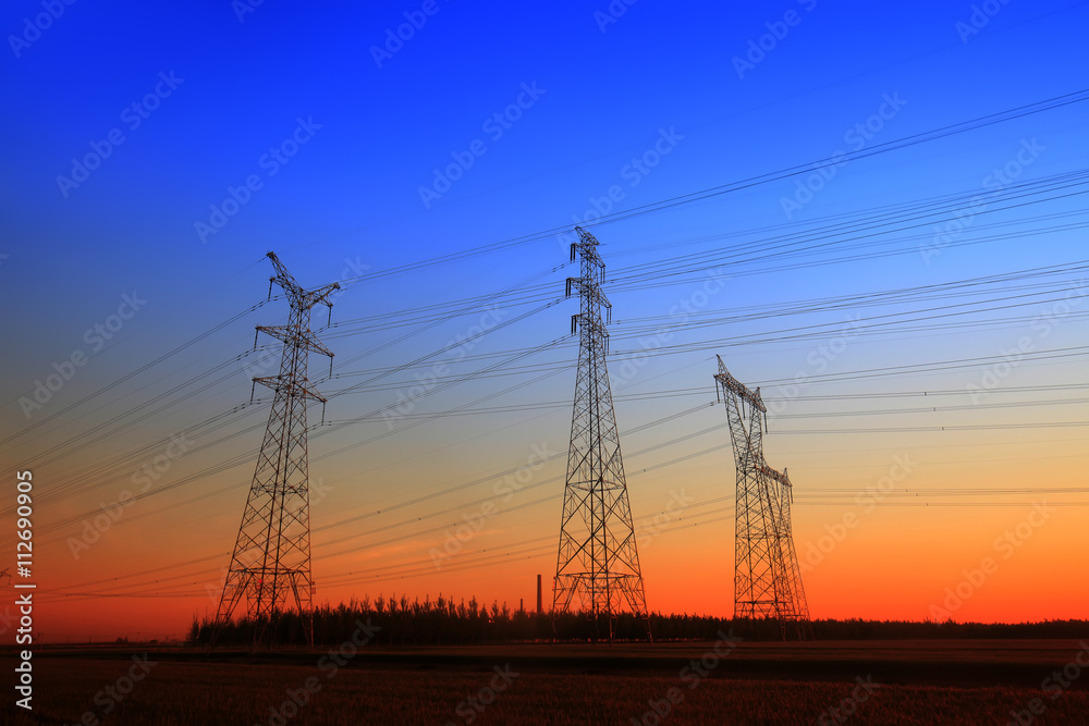 The silhouette of the evening electricity transmission pylon