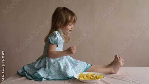 Girl with potato crisps stirring her toes photo