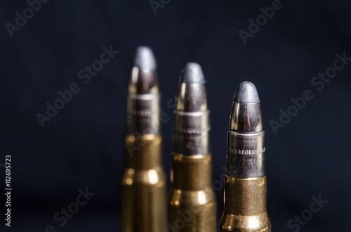 Ammunition on a dark blue background with reflection in a glass. Close up. Weapons. Bullets