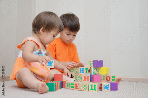 Brother and little sister constructing with toy cubes