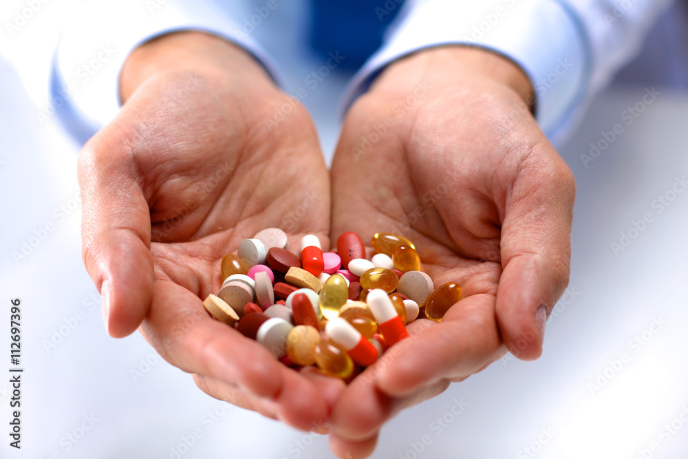Hand of doctors holding many different pills Hand of doctors holding many different pills