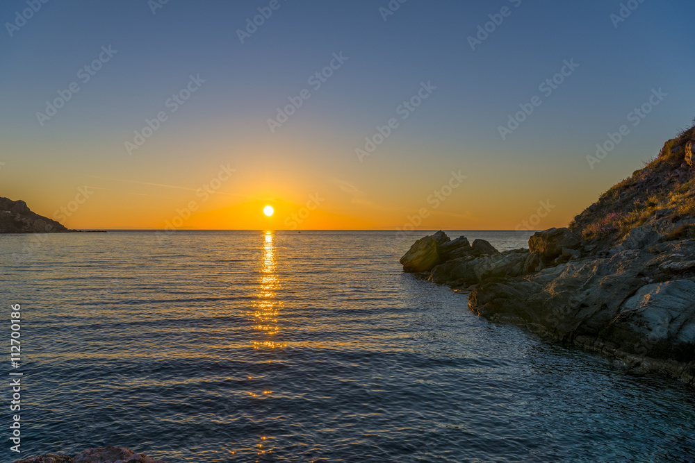 Amazing sunset in the sea. The sun falls into the Aegean sea cre