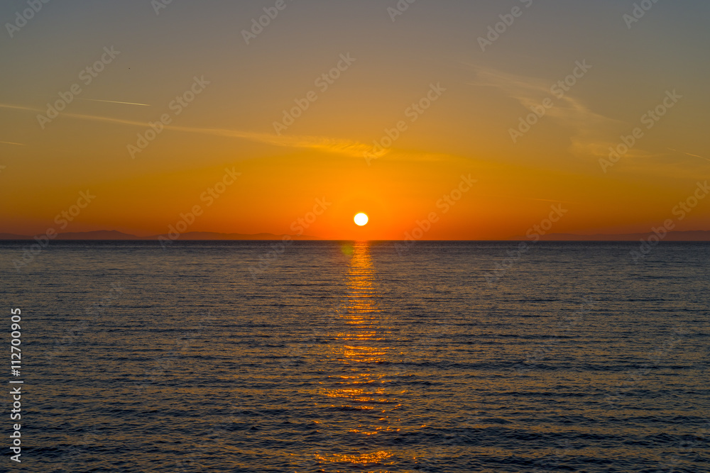 Amazing sunset in the sea. The sun falls into the Aegean sea cre