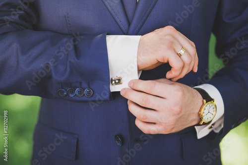 Man in suit. Mail dress fashion. Close up of man hands and sleeves of blue suit and white shirt. Groom, businessman or groomsman.
