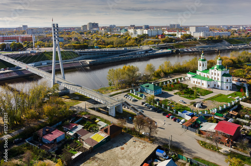 Tyumen  Russia - September 24  2015  Aerial view onto pesestrian Lovers Bridge on Tura river and Voznesensko-Georgiyevsky church