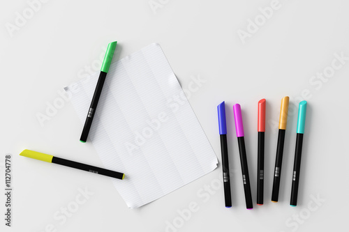 Colorful pens with sheet of paper
