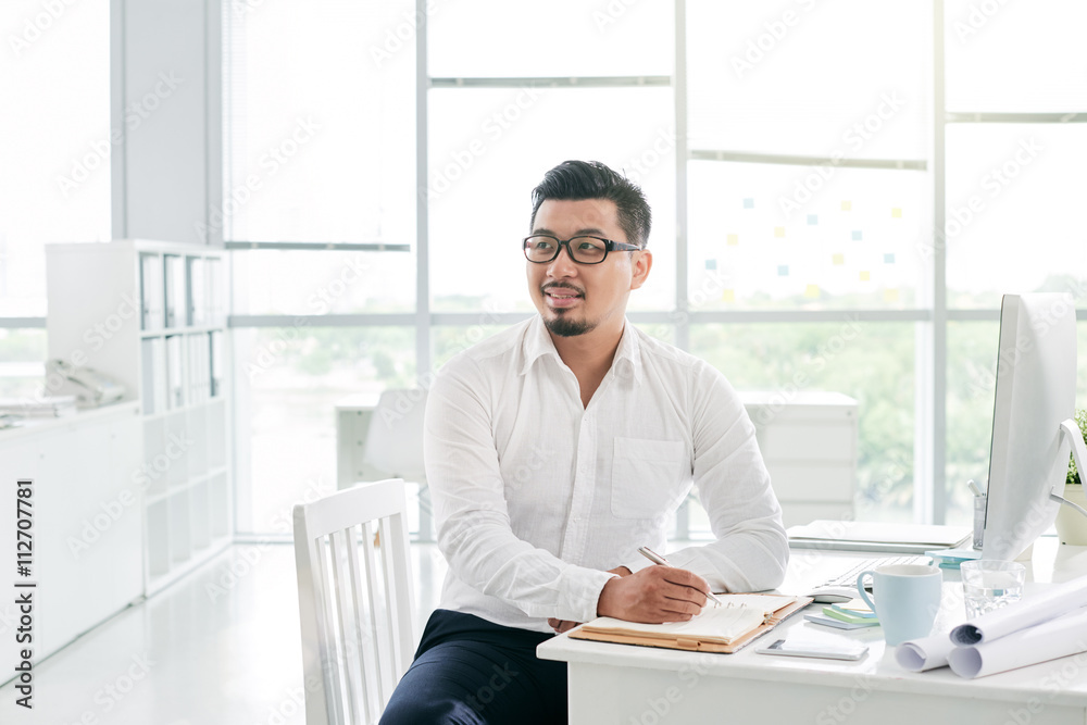Portrait of Asian businessman taking notes in notepad Portrait of Asian businessman taking notes in notepad