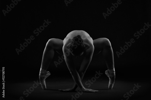 Art nude. Perfect flexible sexy body of young woman on black background