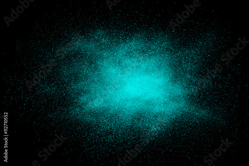 Cyan abstract powder explosion on a black background