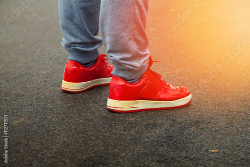 red sneakers are asphalt with sunlight in the frame