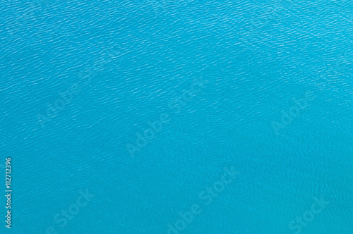 Water surface background. Calm, slightly rippled water surface shot from above