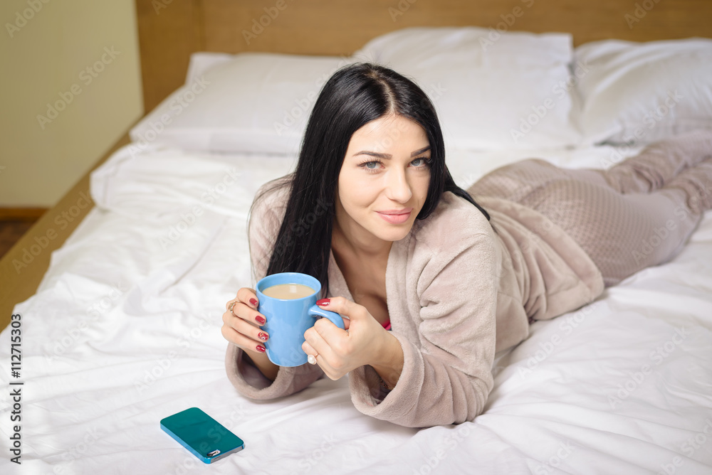 Sexy beautiful woman in bed drinking coffee tea with smartphone, portrait Sexy beautiful woman in bed drinking coffee tea with smartphone, portrait