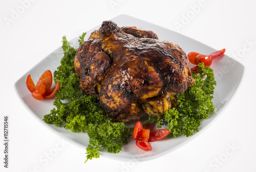 Roast chciken served on a white plate on a white background. photo