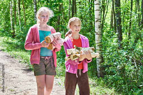 Girls carry firewood from forest