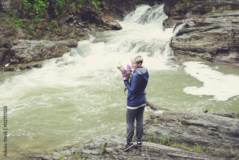 Obraz premium Happy young traveler woman hiking travelling in the forest on a sunny day. Beautiful blond hipster girl outdoors in the forest mountains near river