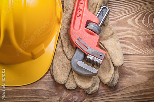 Hard hat protective gloves monkey wrench on wooden board constru photo