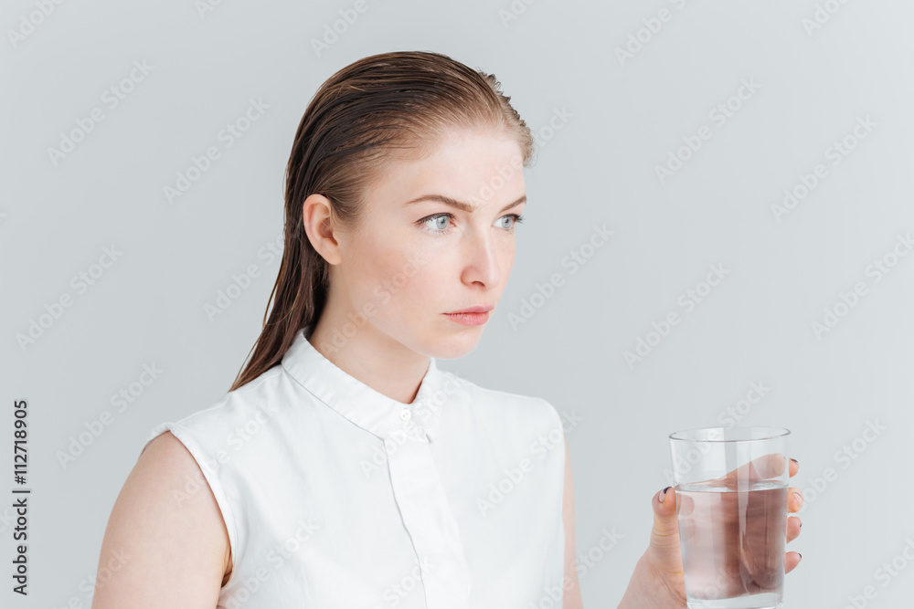 Thoughtful woman holding glass with water Thoughtful woman holding glass with water