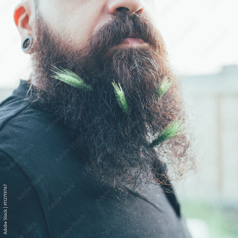  portrait of millennial bearded man with ears of corn on it