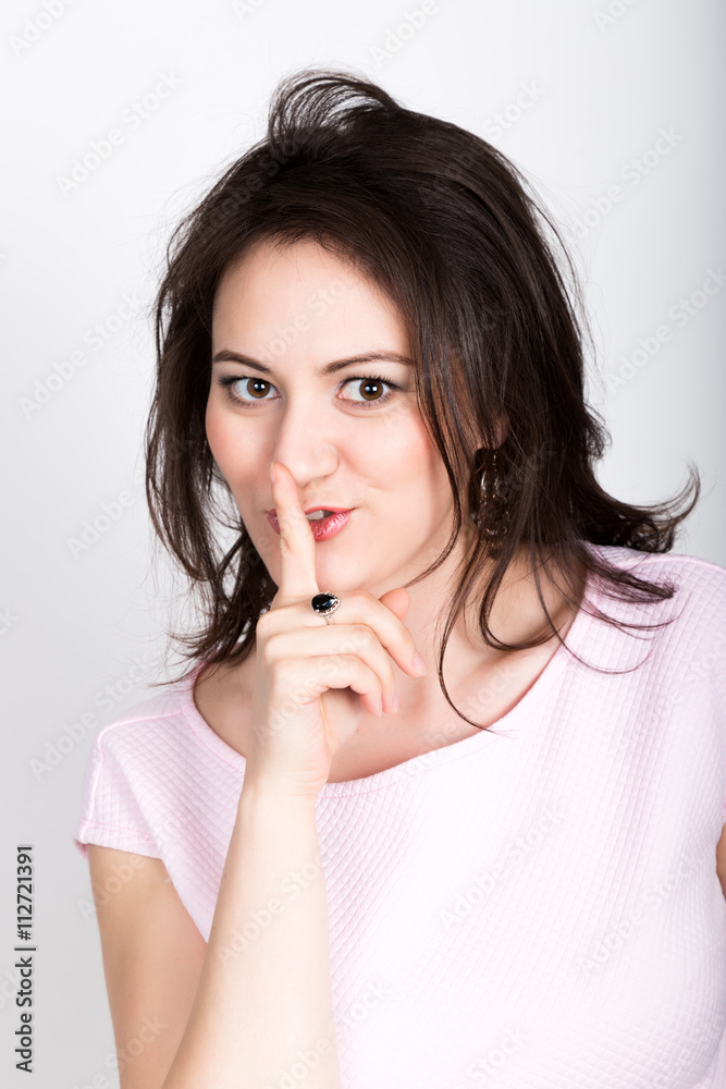 Hush-hush. beautiful brunette woman closes mouth by hand. girl flirting concept. expression of different emotions Hush-hush. beautiful brunette woman closes mouth by hand. girl flirting concept. expression of different emotions