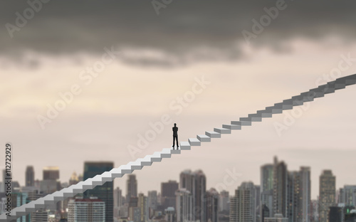 Businessman climbing on a ladder over a city looking ahead, Leadership concept