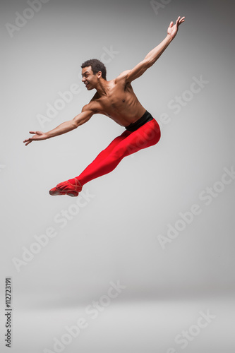 Young and stylish modern ballet dancer on gray background