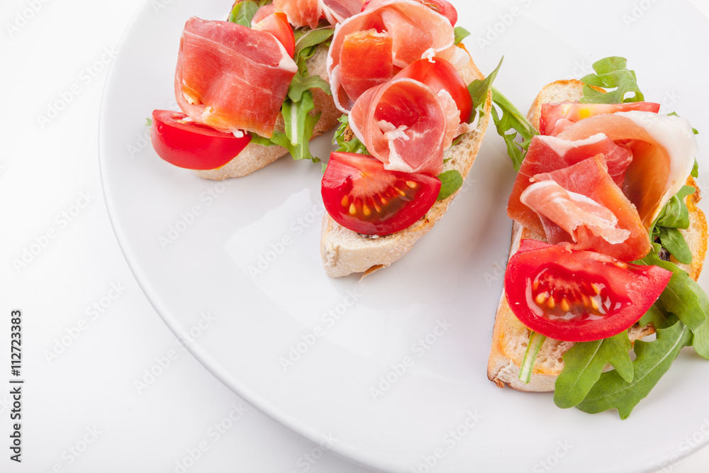 Jamon. Slices of Bread with Spanish Serrano Ham Served as Tapas. Cured ham, spanish appetizer. Prosciutto isolated on white background Jamon. Slices of Bread with Spanish Serrano Ham Served as Tapas. Cured ham, spanish appetizer. Prosciutto isolated on white background