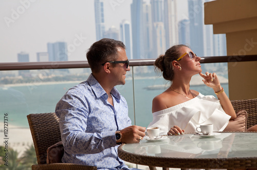 Luxury travel vacation couple with coffee looking at view on Dub