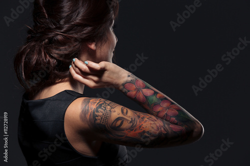 Valokuva Back view of pretty young woman with tattooed hand