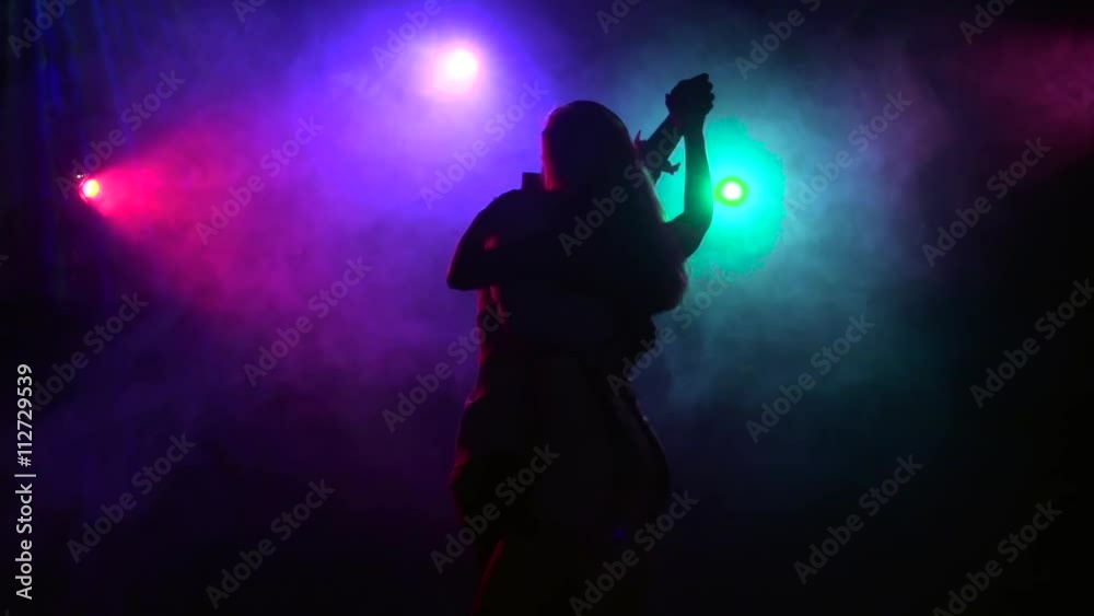 Silhouette of dancing couple in disco style. Close-up. Slow motion