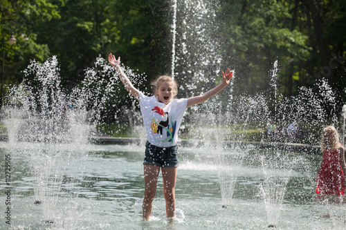 Enjoy fountain  young girl bathes in a city fountain  